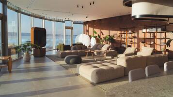 A spacious living area with a large sofa set, a coffee table, and a bookshelf.