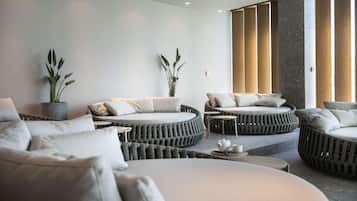 A modern, minimalist lounge area with round seating and potted plants.