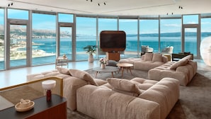 A modern living room with a large TV, comfortable seating, and a view of the sea. - Radisson Blu Resort & Spa, Split (Split)