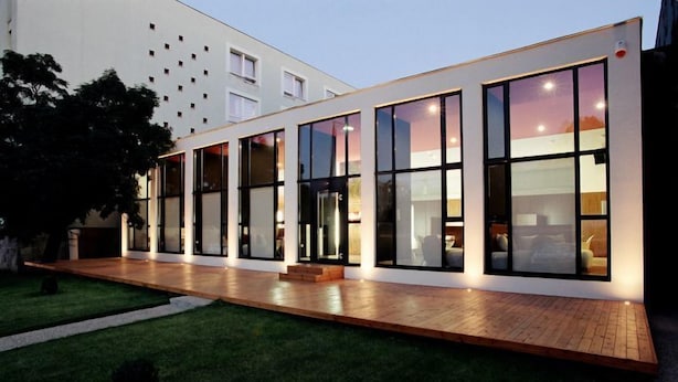 A modern building with large windows and a wooden deck. - Hotel Laterum (Pecs)