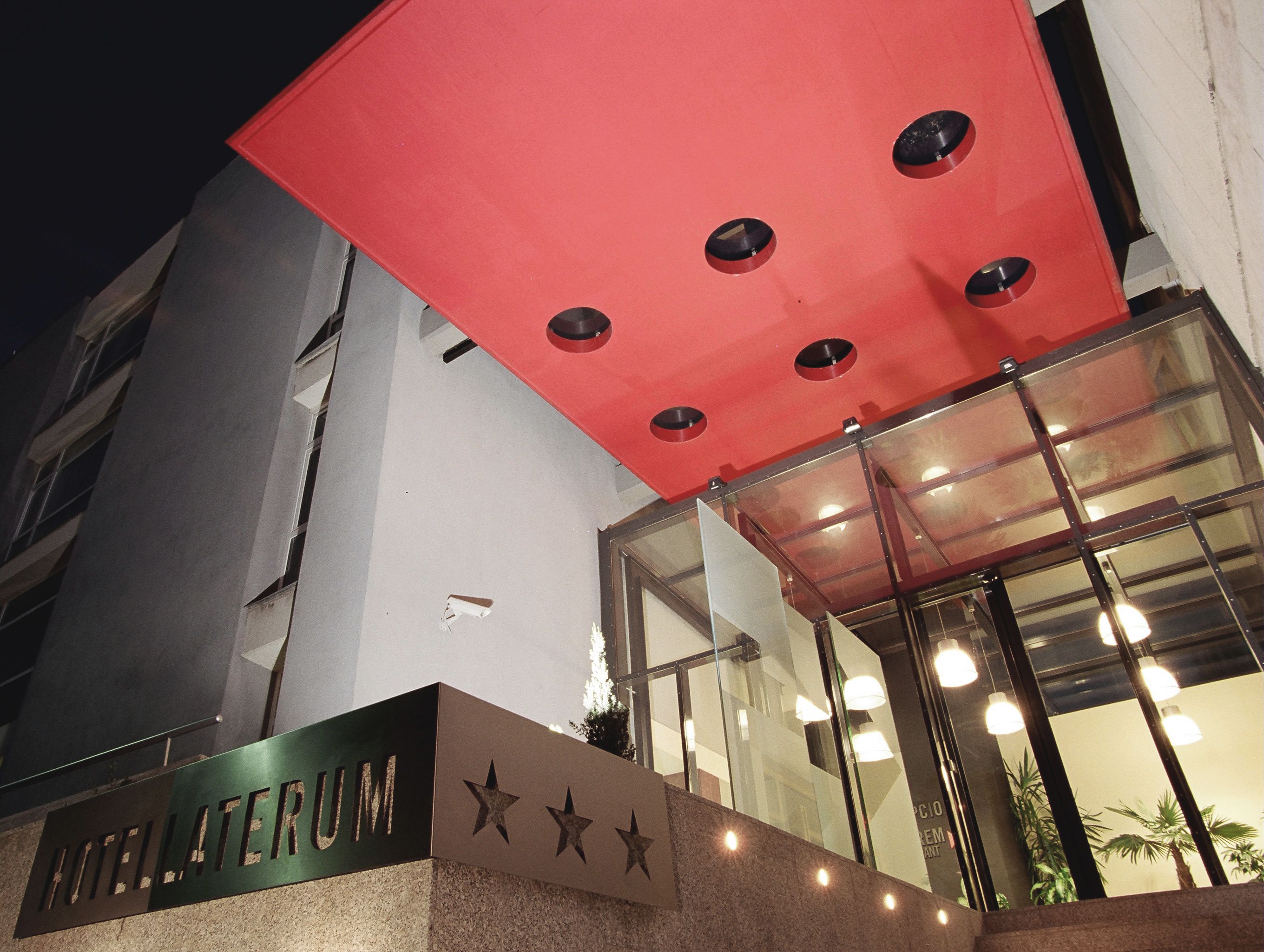 Entrada de hotel com uma placa indicando "HOTEL LATERUM".