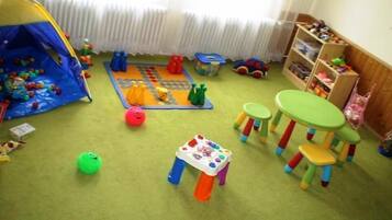 Children can play and learn in this vibrant playroom with a tent, play mat, and blocks.