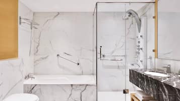A modern bathroom with a glass-enclosed shower, a white bathtub, and a marble-topped vanity.
