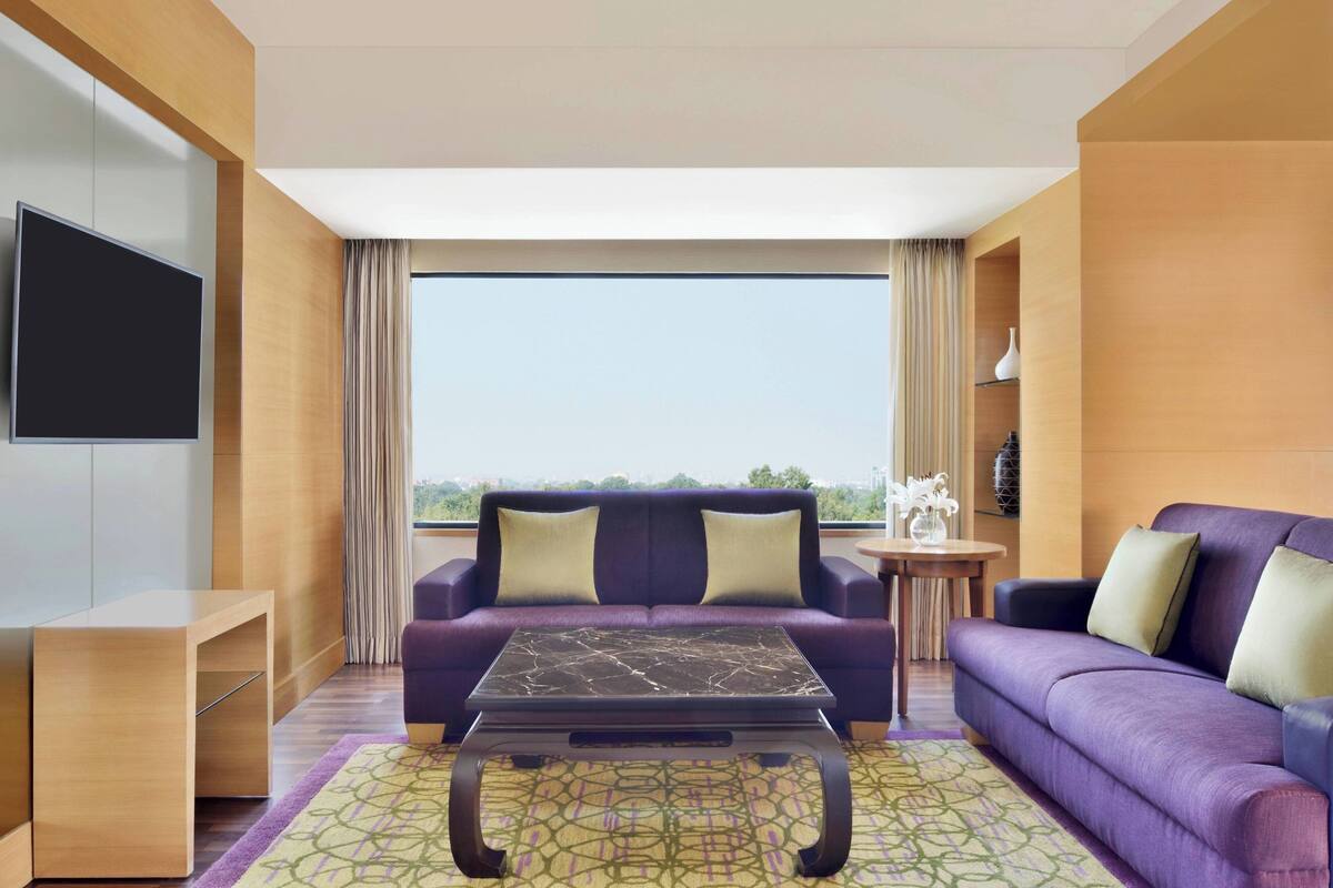 Un salon moderne avec un canapé, une table basse et un téléviseur fixé au mur.