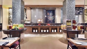 Um restaurante moderno com ilha central, cadeiras de madeira e backsplash de azulejos.