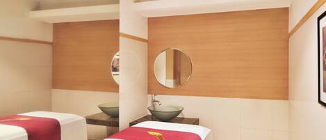Een hotelkamer met twee bedden, een wand van hout, een ronde spiegel en een wastafel.