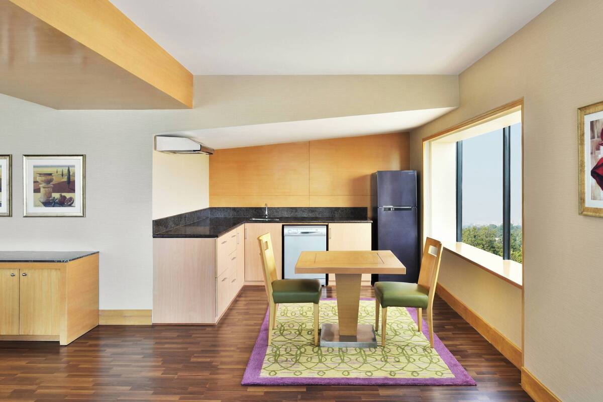 Une cuisine moderne avec des meubles en bois, un plan de travail noir et un lave-vaisselle encastré.