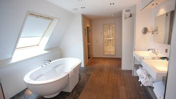 A modern bathroom with a freestanding bathtub, a walk-in shower, and a vanity with a mirror.