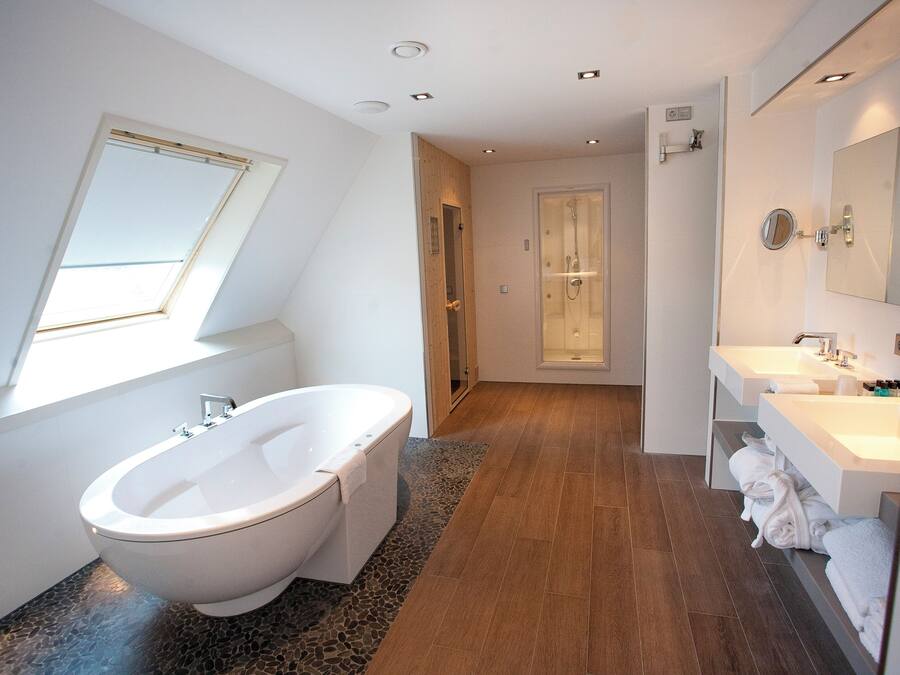 A modern bathroom with a freestanding bathtub, a walk-in shower, and a vanity with a mirror.