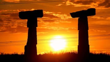 Two stone crosses silhouetted against a sunset.