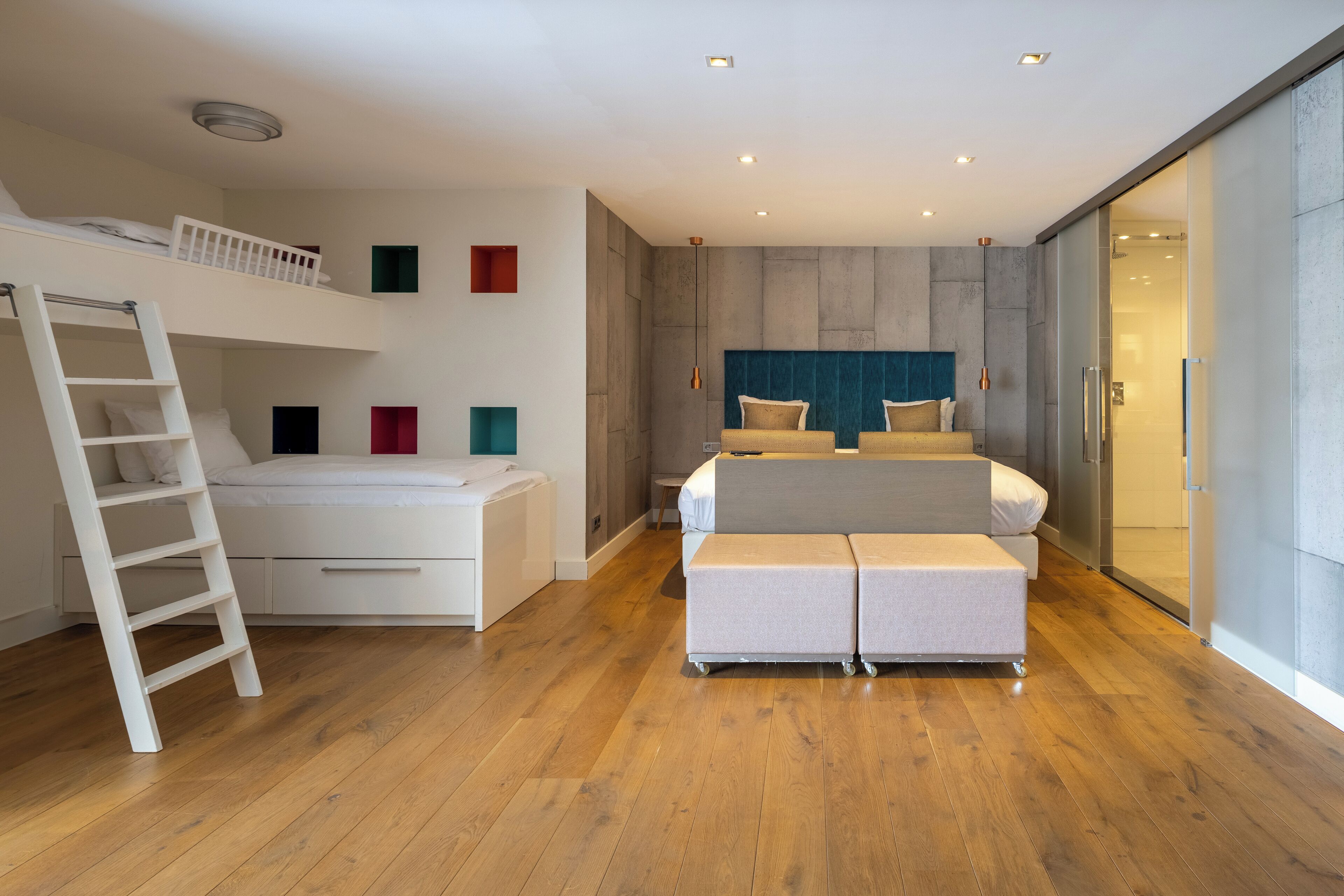 Un dormitorio moderno con una cama litera, un escritorio y un sofá.