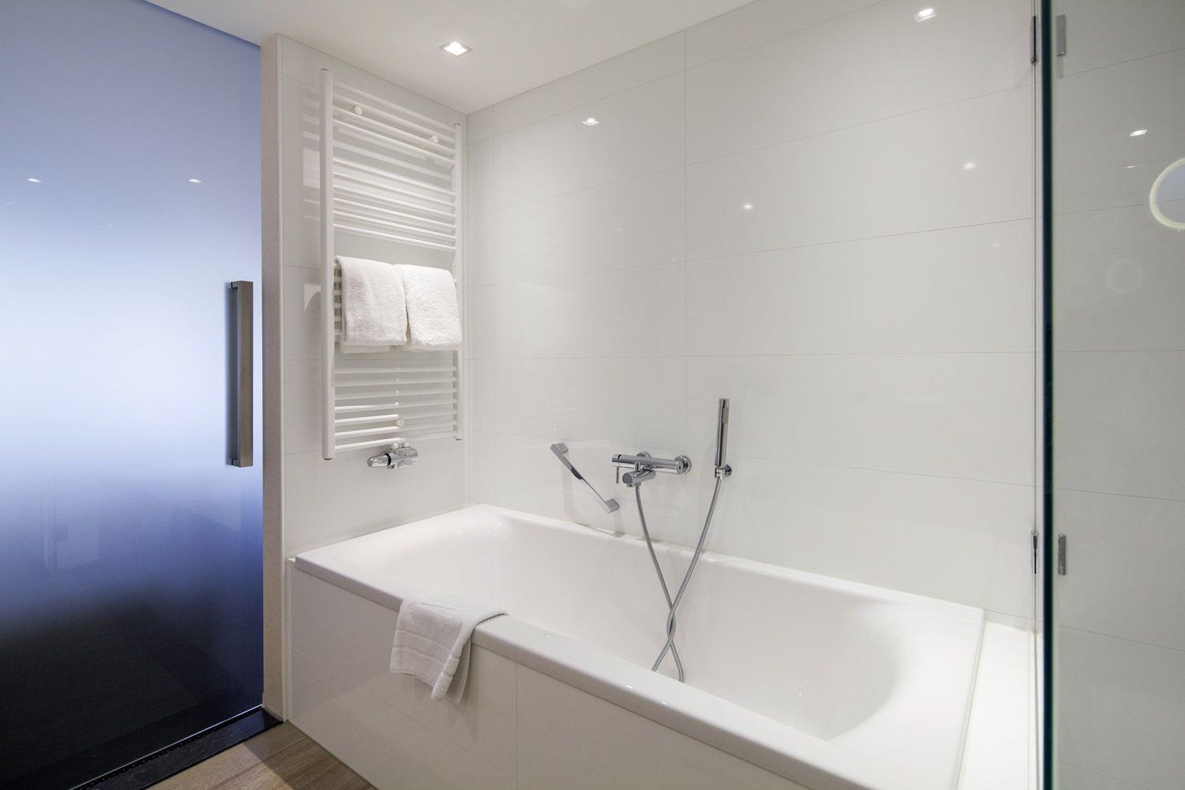 Un baño moderno con bañera, ducha y mampara de vidrio.