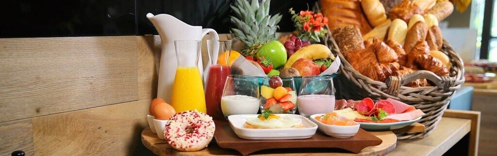 A breakfast buffet with various fruits, pastries, and beverages.