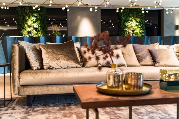 A modern living room with a beige sofa, a wooden coffee table, and decorative items.