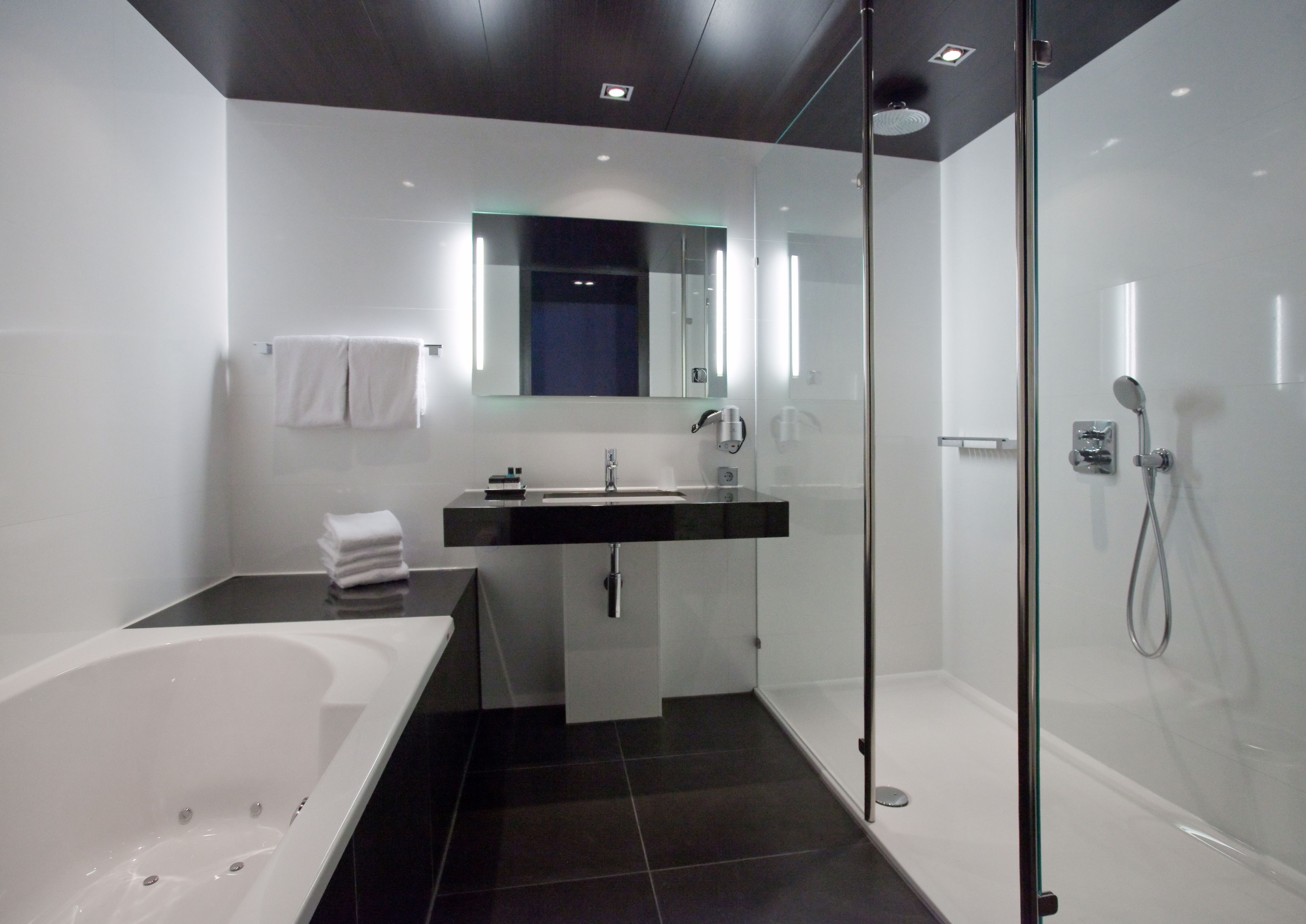 A modern bathroom with a bathtub, a sink, and a shower.
