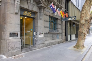 Alto Hotel on Bourke Street features a modern entrance with a glass facade and a balcony area.
