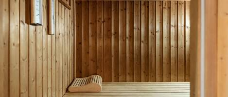 Una sauna de madera con un banco e iluminación en la pared.
