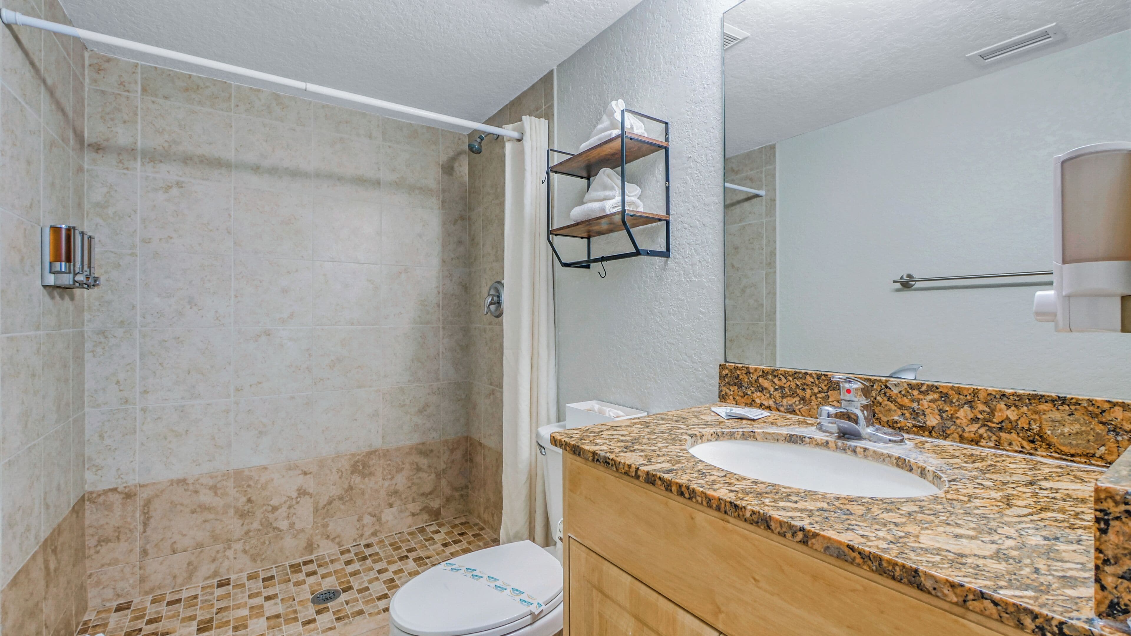 Ein Badezimmer mit Dusche, Toilette und Waschbecken.
