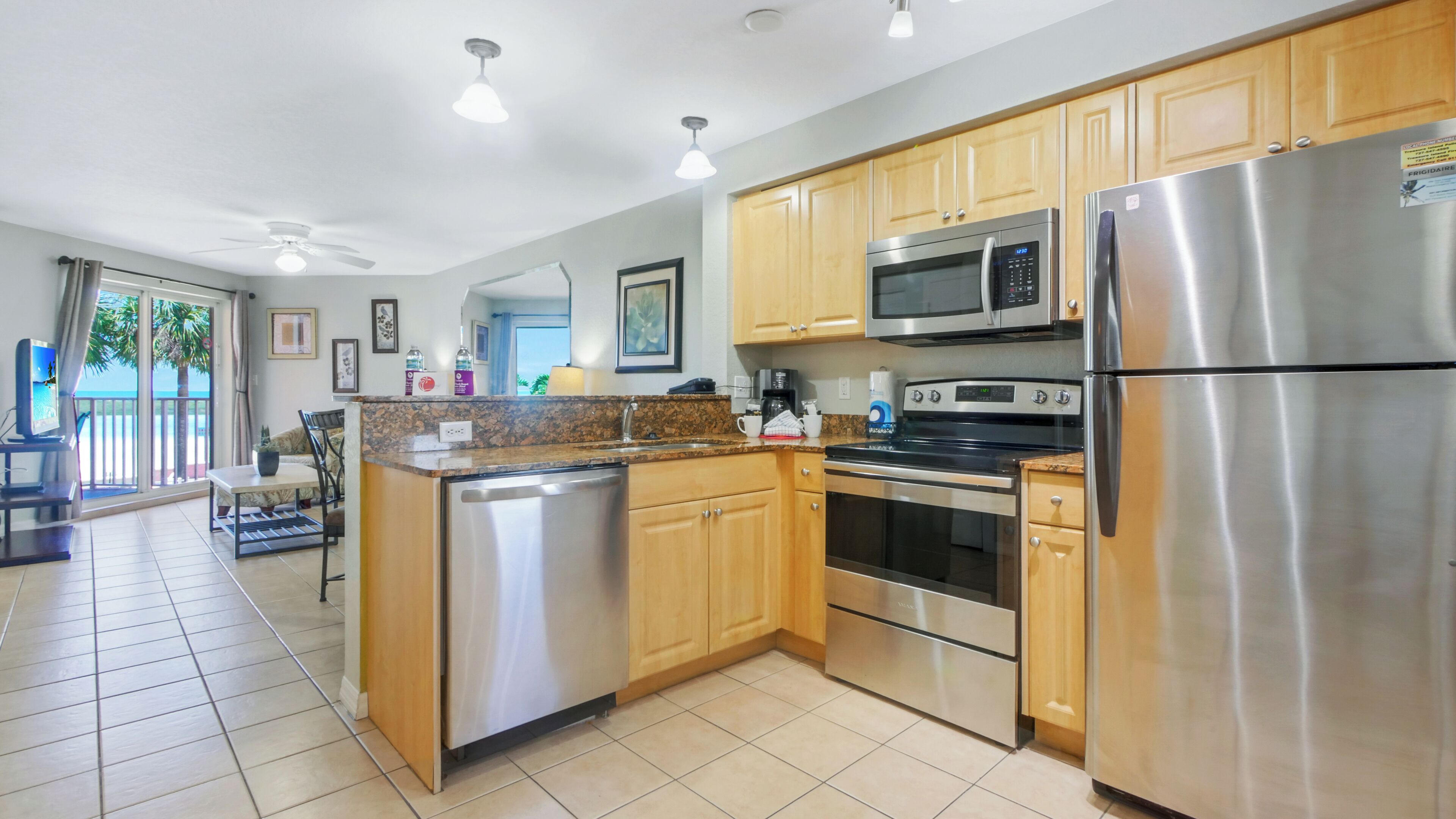 A modern kitchen with stainless steel appliances, wooden cabinets, and a central island.