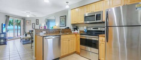 A modern kitchen with stainless steel appliances, wooden cabinets, and a central island.