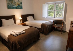 A hotel room with two beds, a nightstand, a chair, a window with curtains, and a painting on the wall. - Postales Finca & Bodega by DOT Boutique (Tunuyan)