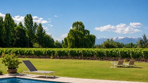 A swimming pool with lounge chairs and a view of mountains. - Postales Finca & Bodega by DOT Boutique (Tunuyan)