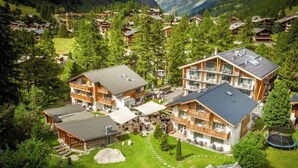 Un resort con varias construcciones, zonas de estar al aire libre y un césped bien cuidado.