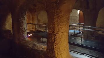 An underground passageway with stone pillars and metal railings.