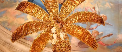 A chandelier with golden, leaf-like decorations.