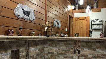 Een badkamer met een groot bad, houten wanden en een backsplash van stenen mozaïek.