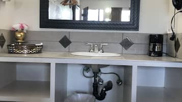 Une salle de bain avec un lavabo, un miroir et un meuble-lavabo.
