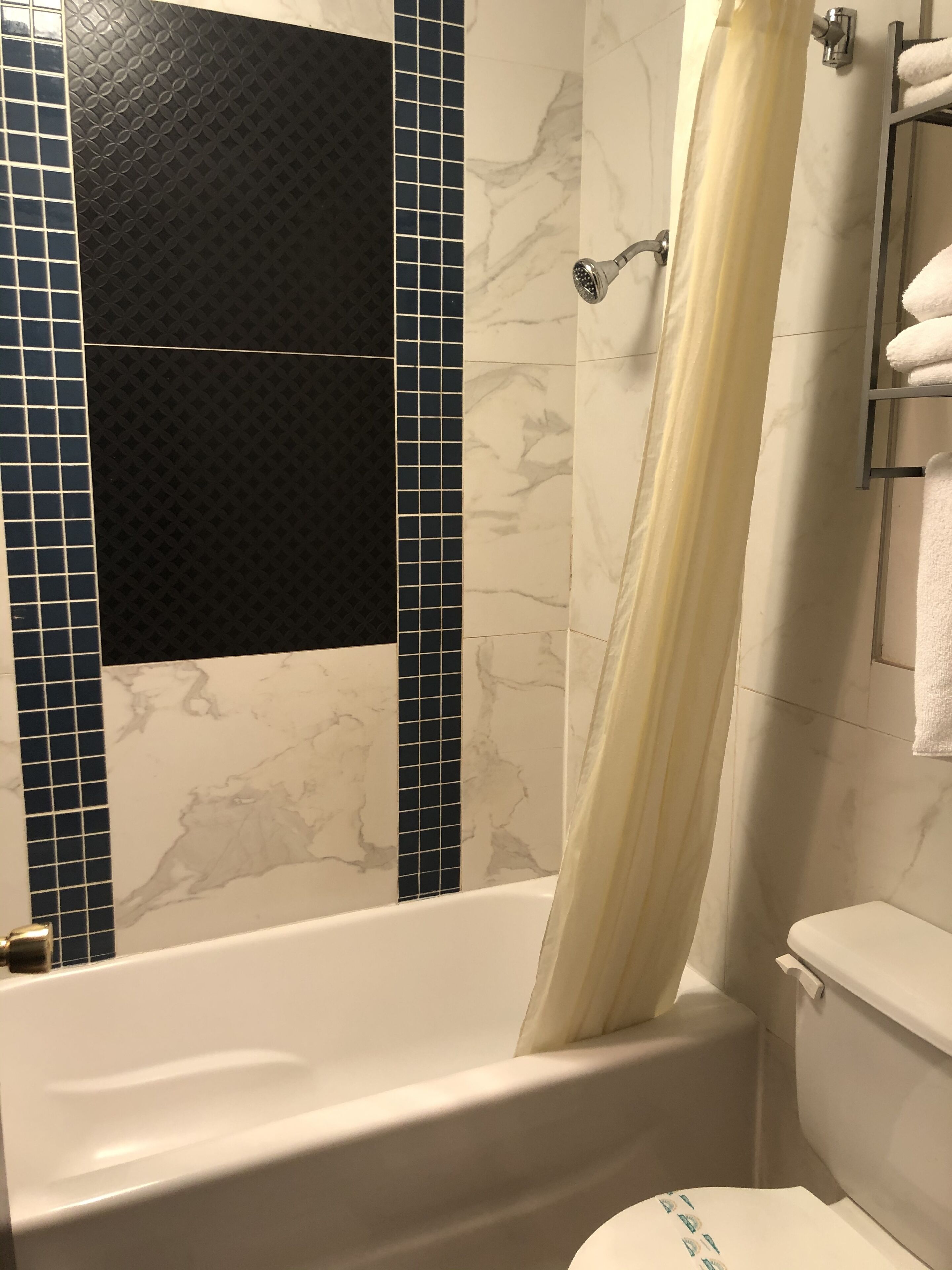 Un baño con bañera, inodoro y cortina de ducha.