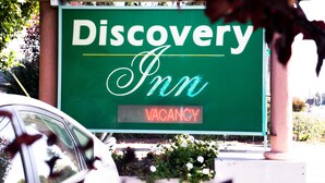 Señal verde para Discovery Inn con un aviso de 'NO VACANCY'.