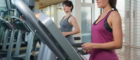 A gym with treadmills and a person using one.