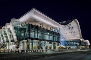 Un bĂątiment moderne dotĂ© dâune conception architecturale unique, caractĂ©risĂ© par de grandes fenĂȘtres en verre et un motif gĂ©omĂ©trique distinctif sur la façade.