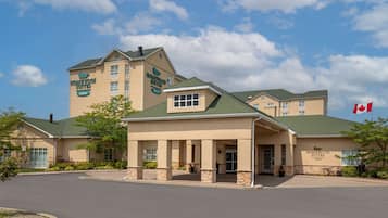 Classic hotel exterior with a covered entrance and greenery.