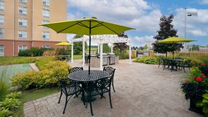 A patio area with outdoor seating, a pergola, and a pool.
