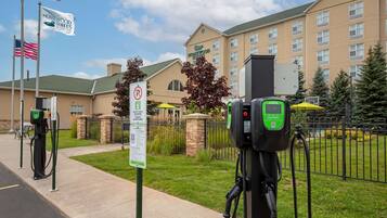 Un hotel con estacionamiento y puntos de carga para vehículos eléctricos.