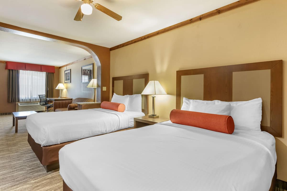 Una habitación de hotel con dos camas, un escritorio y una silla.