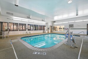An indoor swimming pool with clear water, surrounded by a tiled deck and a lifeguard station. - Country Inn & Suites by Radisson, Merrillville, IN (Merrillville)