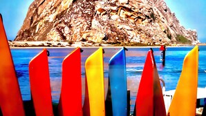 A rocky island with a clear blue sea in the foreground. - Morro Bay Beach Inn (Morro Bay)