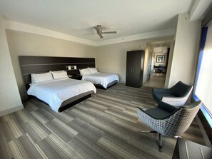 Une chambre d’hôtel avec deux lits, une armoire, un bureau et une chaise.
