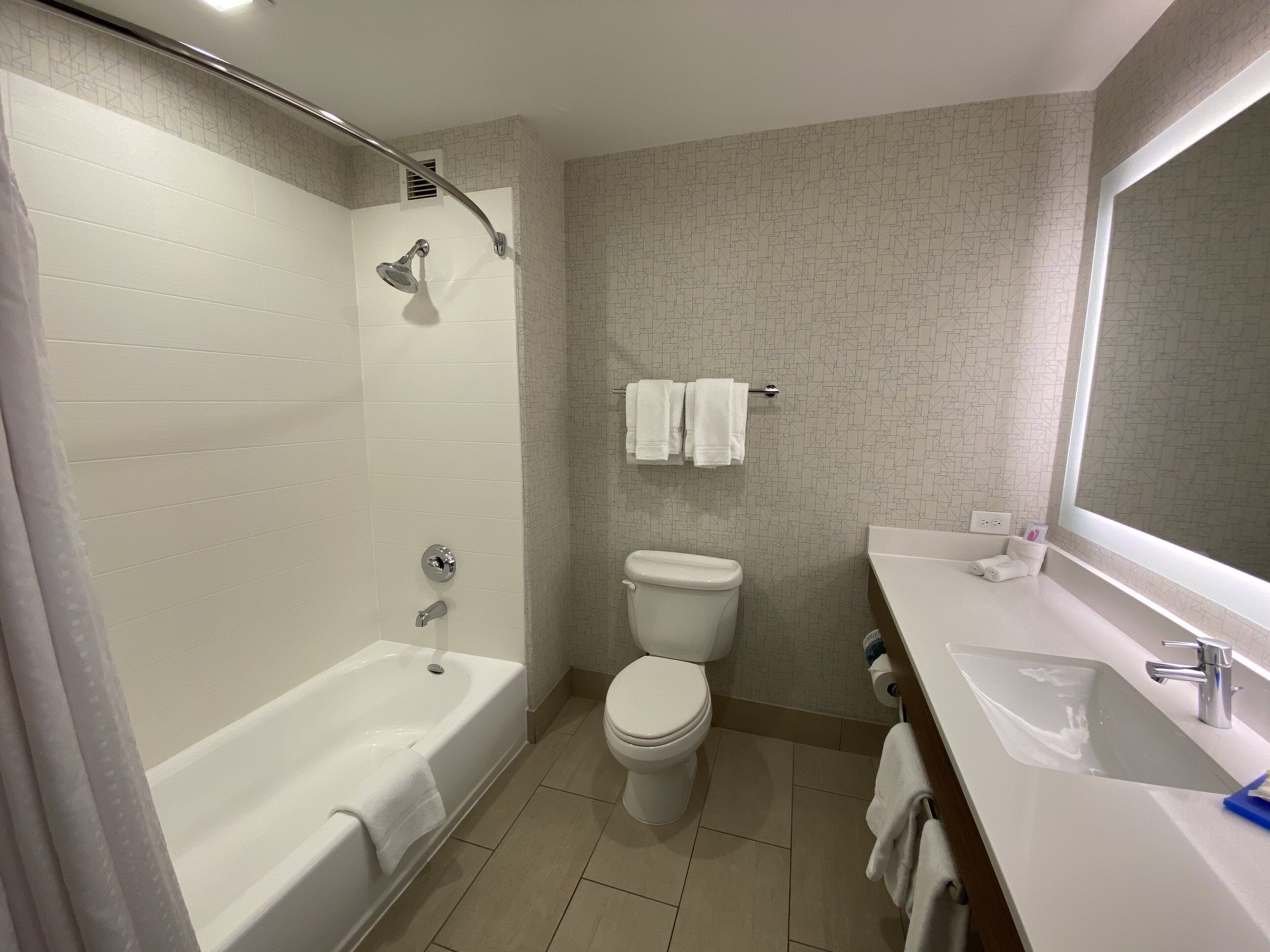 A modern bathroom with a bathtub, toilet, and sink.