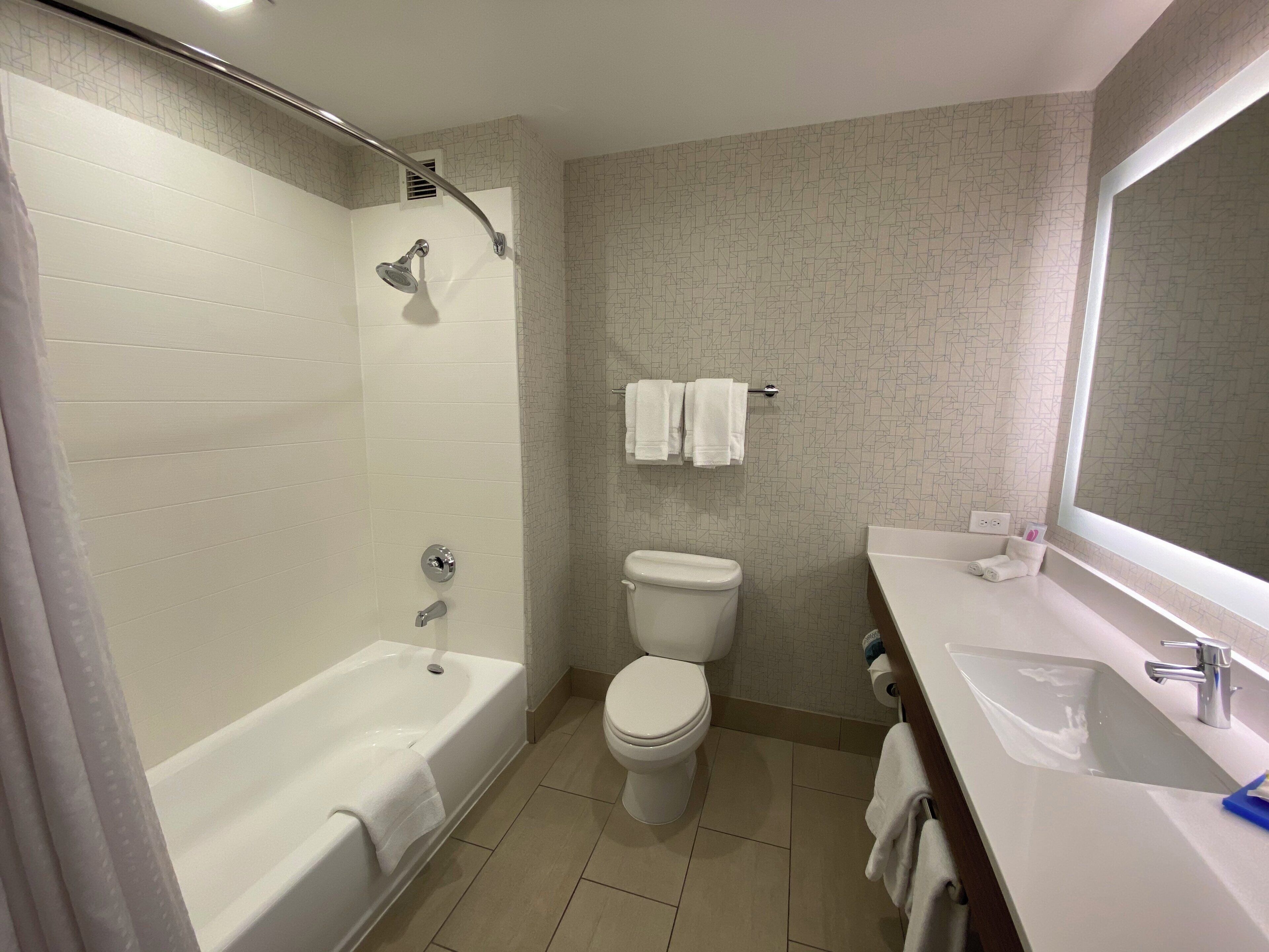 A bathroom with a bathtub, toilet, and sink.