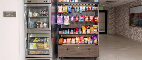A treats shop with a refrigerator and a display of snacks.