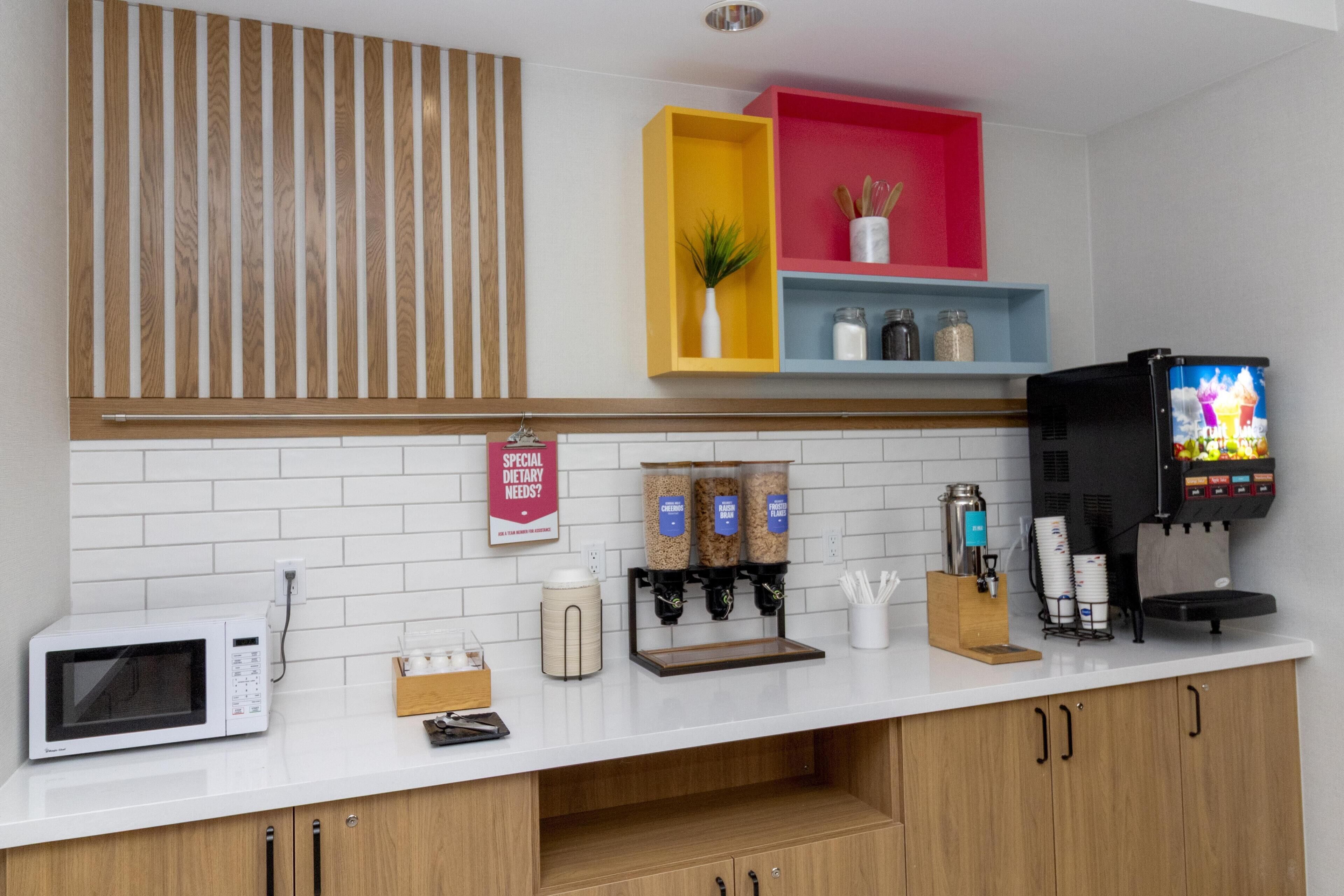 Une cuisine équipée d’un four à micro-ondes, d’une machine à café et d’un distributeur de boissons.