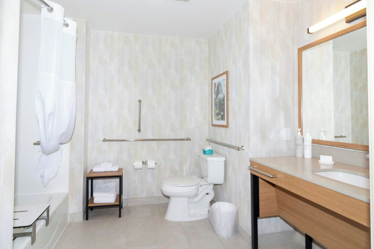 A modern bathroom with a shower, toilet, and vanity.