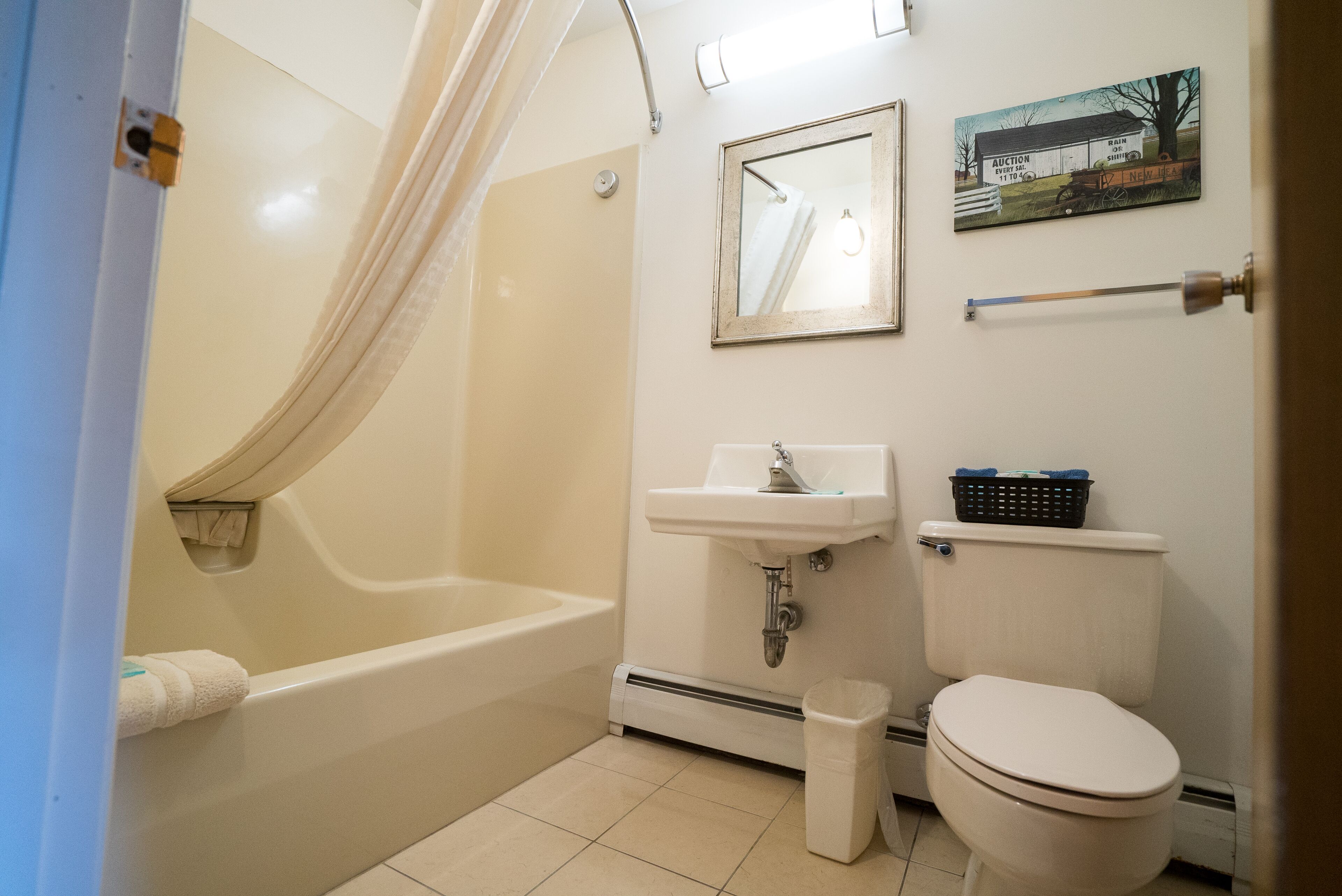 A bathroom with a bathtub, sink, toilet, and a shower curtain.