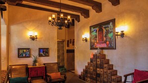 A cozy lobby with leather chairs, a wooden staircase, and wall-mounted lighting. - Tubac Golf Resort & Spa (Tubac)