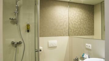 Ein modernes Badezimmer mit einer Duschkabine, einer Toilette und einem Waschbecken.